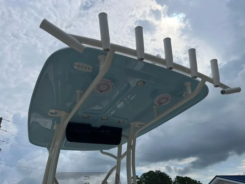 Slide: The Image of 2026 Pioneer 222 Islander boat top with rod holders against cloudy sky. - 23