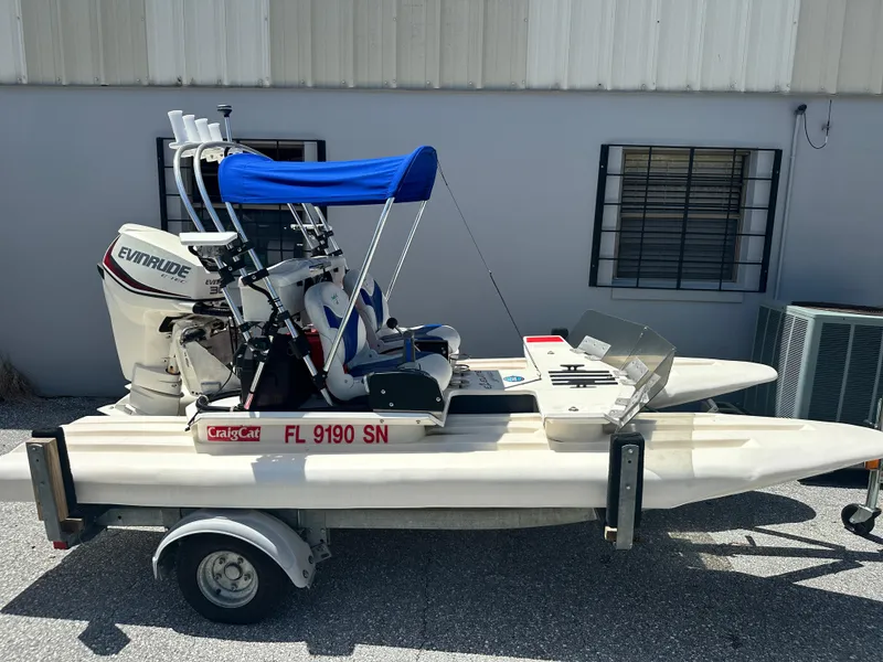 Slide: The Image of 2020 CraigCat E2 Elite boat with Evinrude motor on trailer, parked outside a building. - 12