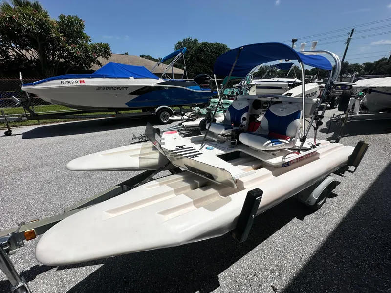 Slide: The Image of 2020 CraigCat E2 Elite catamaran with blue canopy on a trailer, parked outdoors. - 16