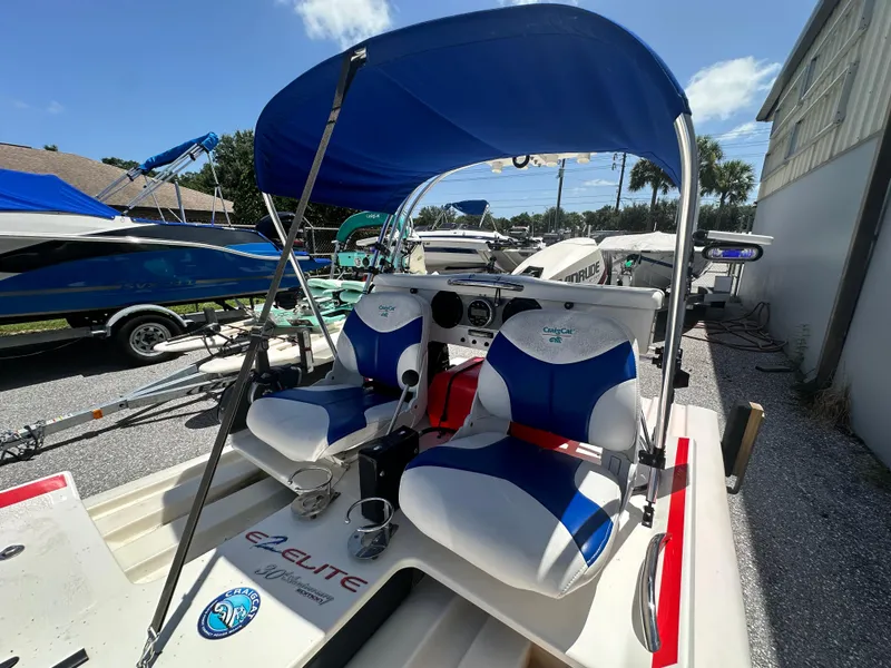 Slide: The Image of 2020 CraigCat E2 Elite boat with blue canopy and dual seats, parked outdoors. - 17