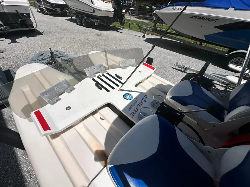 Slide: The Image of 2020 CraigCat E2 Elite catamaran with blue seats, parked among other boats. - 18