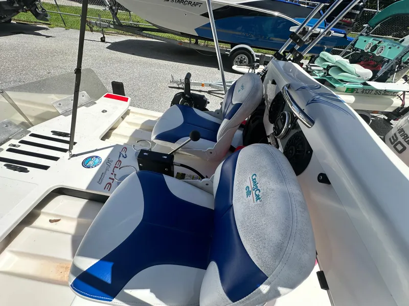 Slide: The Image of 2020 CraigCat E2 Elite boat interior with blue and white seats, steering controls, and dashboard. - 19