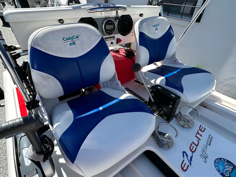 Slide: The Image of 2020 CraigCat E2 Elite boat seats with blue and white design, featuring control panel and cup holders. - 3