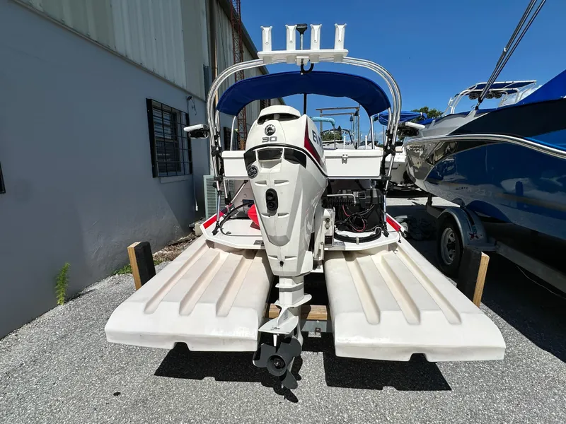 Slide: The Image of 2020 CraigCat E2 Elite with outboard motor, parked outdoors on a sunny day. - 8