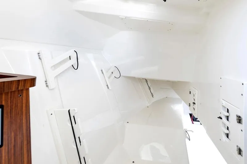 Slide: The Image of Interior view of 2026 Pursuit DC 306 Dual Console boat, featuring sleek white design and wood accents. - 15