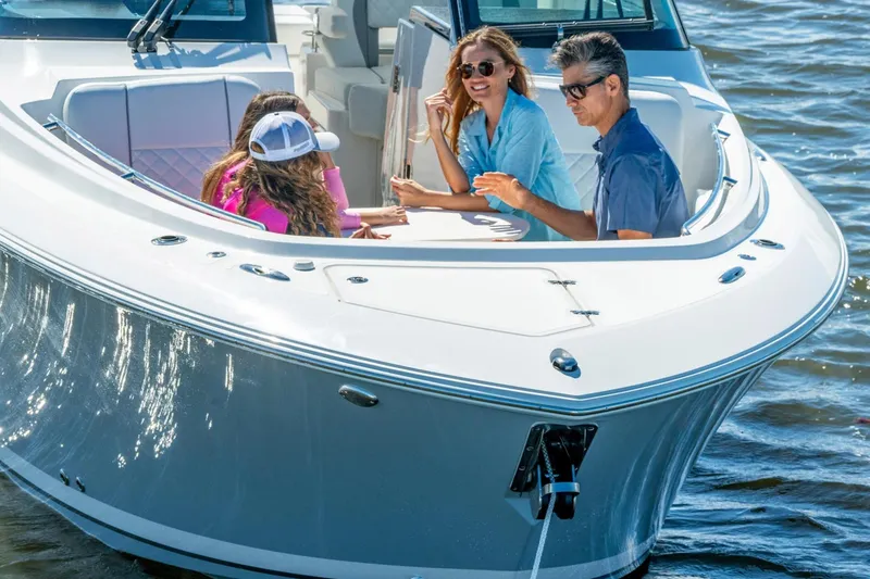 Slide: The Image of Family enjoying a day on a 2026 Pursuit DC 306 Dual Console boat. - 17