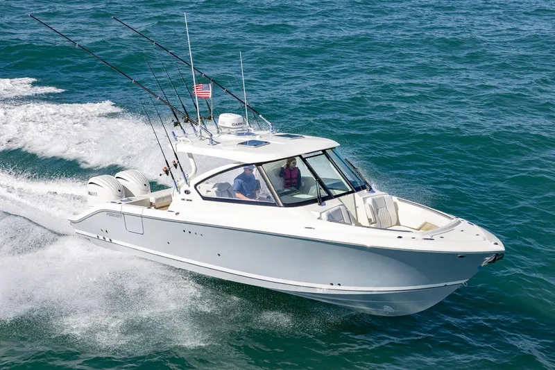 Slide: The Image of 2026 Pursuit DC 306 Dual Console boat cruising on open water. - 2