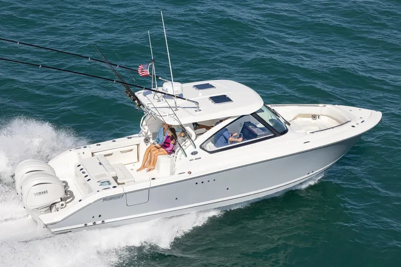 Slide: The Image of 2026 Pursuit DC 306 Dual Console boat cruising on open water. - 3