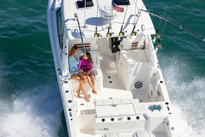 Slide: The Image of 2026 Pursuit DC 306 Dual Console boat cruising with two passengers on deck. - 6