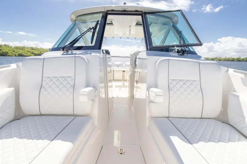 Slide: The Image of 2026 Pursuit DC 306 Dual Console boat interior with white seating and open windshield. - 8