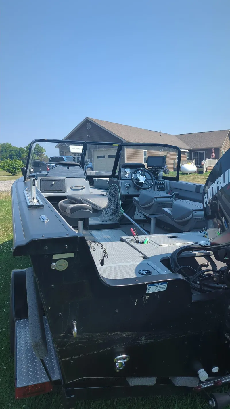 Slide: The Image of 2019 Starcraft Titan 186 boat on trailer, parked outdoors under clear blue sky. - 12