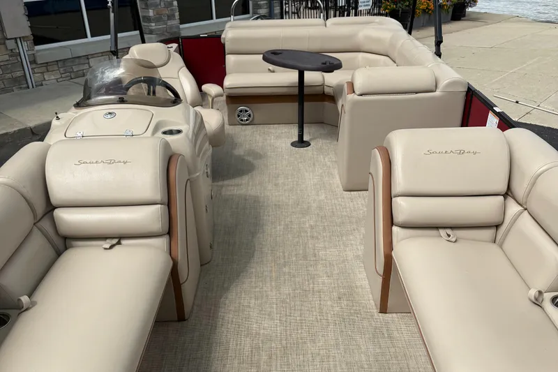 Slide: The Image of 2018 South Bay 523CR pontoon boat with beige seating and a central table. - 8