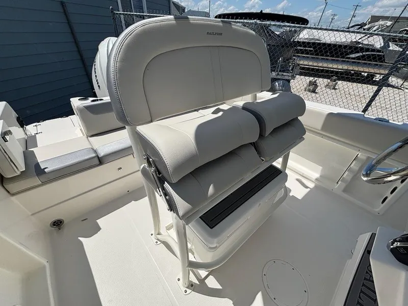 Slide: The Image of 2026 Sailfish 232 CC boat interior with cushioned seating and steering wheel. - 18