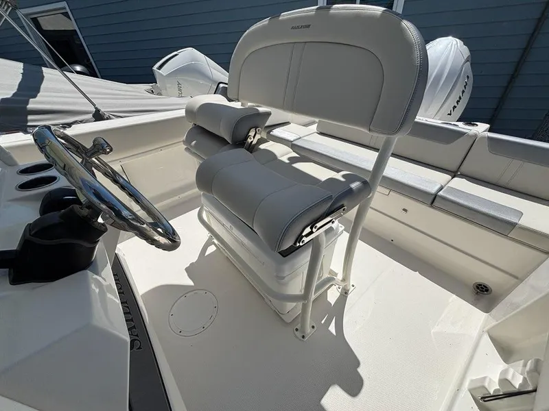 Slide: The Image of 2026 Sailfish 232 CC boat interior with steering wheel and cushioned seating. - 19