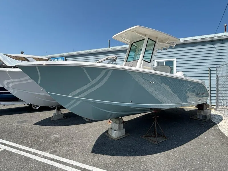 Slide: The Image of 2026 Sailfish 232 CC boat on display, blue hull, parked outdoors. - 2