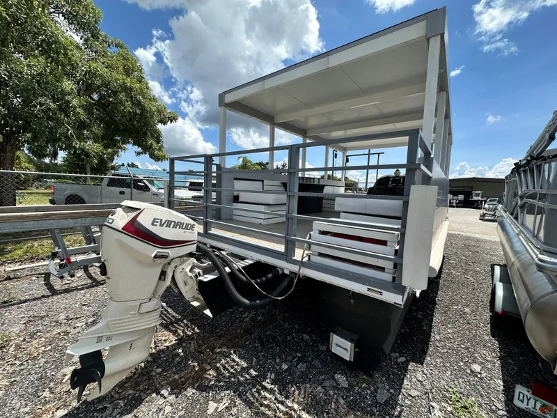 Slide: The Image of 2023 Modern Struktures AGF Cruise boat with Evinrude motor, parked outdoors under blue sky. - 3