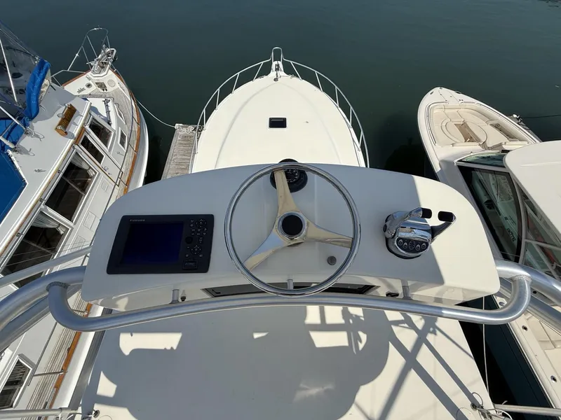 Slide: The Image of 2007 Albemarle 410 Express Fisherman helm with steering wheel and navigation controls, docked at marina. - 16