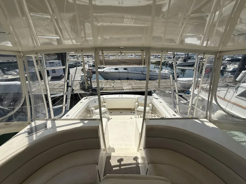 Slide: The Image of 2007 Albemarle 410 Express Fisherman interior view at marina, showcasing seating and deck area. - 19
