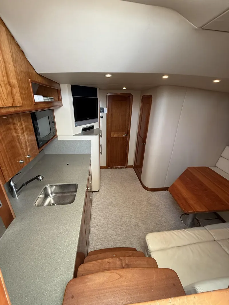 Slide: The Image of Interior of 2007 Albemarle 410 Express Fisherman with kitchenette, seating, and wooden cabinetry. - 21