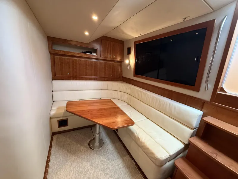 Slide: The Image of 2007 Albemarle 410 Express Fisherman interior with white seating, wooden table, and cabinetry. - 23