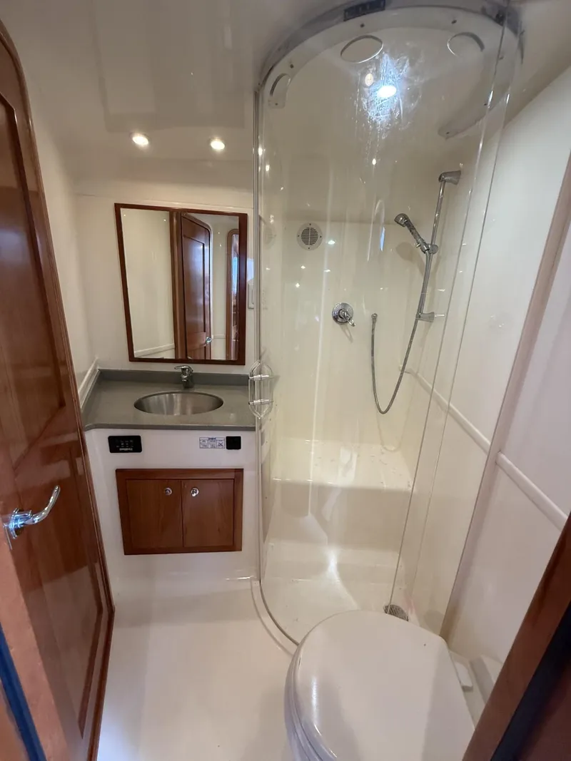 Slide: The Image of 2007 Albemarle 410 Express Fisherman bathroom with shower, sink, and wooden cabinetry. - 24