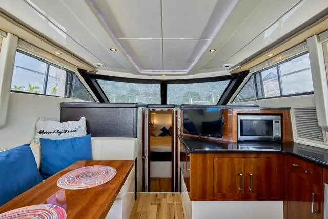 Slide: The Image of Interior of 2015 Carver C34 Command Bridge yacht with modern kitchen and seating area. - 1