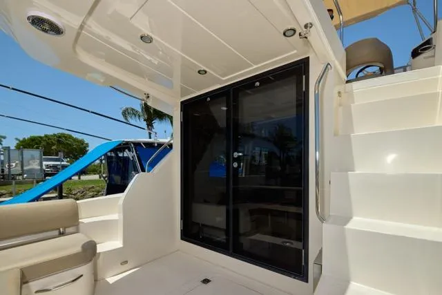 Slide: The Image of 2015 Carver C34 Command Bridge yacht with sliding glass doors and staircase, exterior view. - 11
