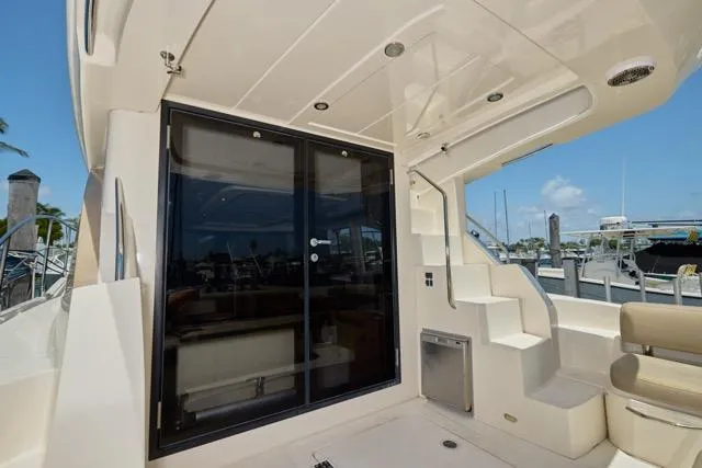 Slide: The Image of 2015 Carver C34 Command Bridge yacht with sliding glass doors and outdoor seating area. - 13