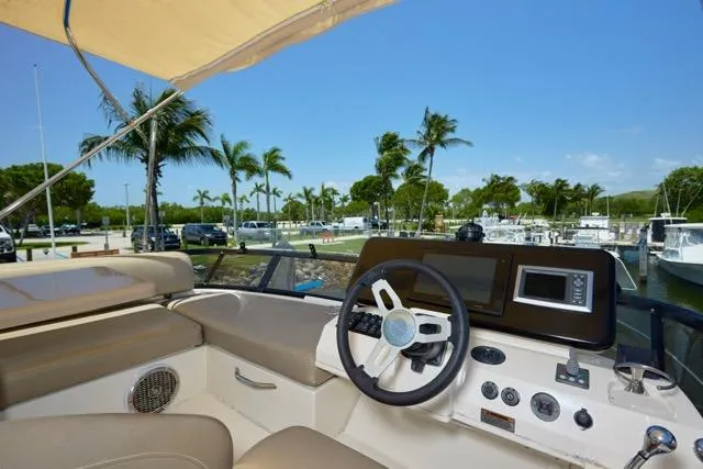 Slide: The Image of 2015 Carver C34 Command Bridge helm with palm trees and marina view. - 17