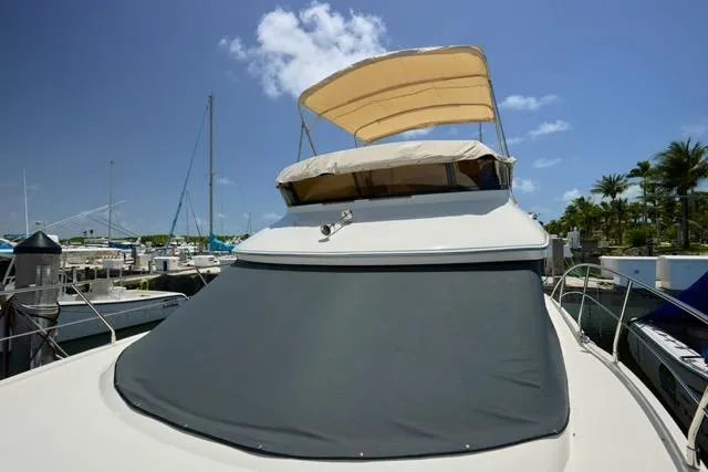Slide: The Image of 2015 Carver C34 Command Bridge yacht docked under clear blue sky. - 24