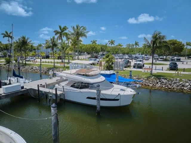 Slide: The Image of 2015 Carver C34 Command Bridge yacht docked at a marina with palm trees. - 35