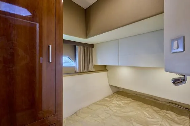 Slide: The Image of Interior cabin of 2015 Carver C34 Command Bridge yacht, featuring a cozy bed and wooden cabinetry. - 9