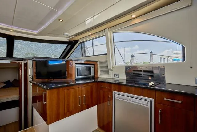 Slide: The Image of Interior of 2015 Carver C34 Command Bridge yacht with modern kitchen amenities. - 10