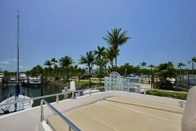Slide: The Image of 2015 Carver C34 Command Bridge yacht docked near palm trees and marina. - 15