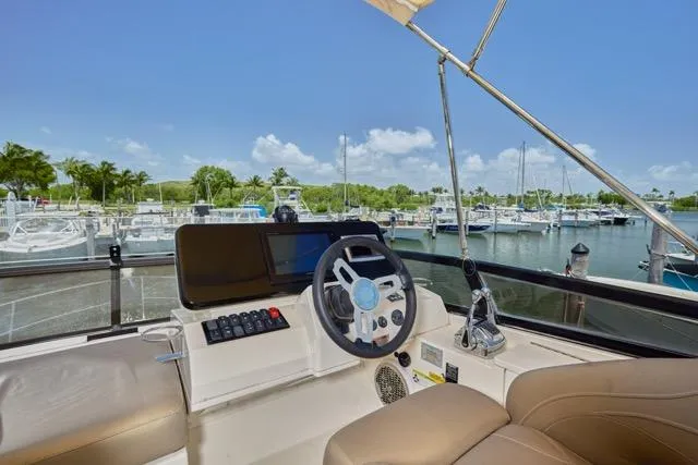 Slide: The Image of 2015 Carver C34 Command Bridge helm with marina view, featuring modern controls and comfortable seating. - 18