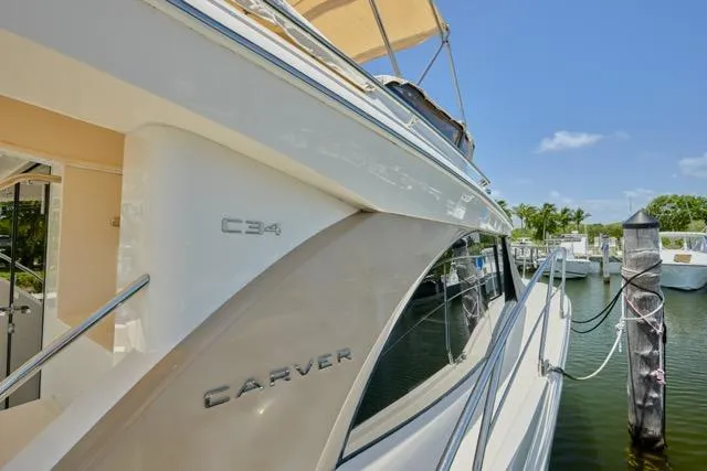 Slide: The Image of 2015 Carver C34 Command Bridge yacht docked at marina under clear blue sky. - 22