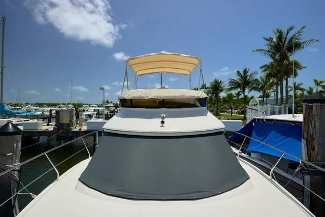 Slide: The Image of 2015 Carver C34 Command Bridge yacht docked at a marina under a clear blue sky. - 23
