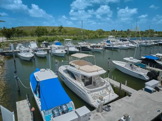Slide: The Image of 2015 Carver C34 Command Bridge yacht docked in a scenic marina under a blue sky. - 30