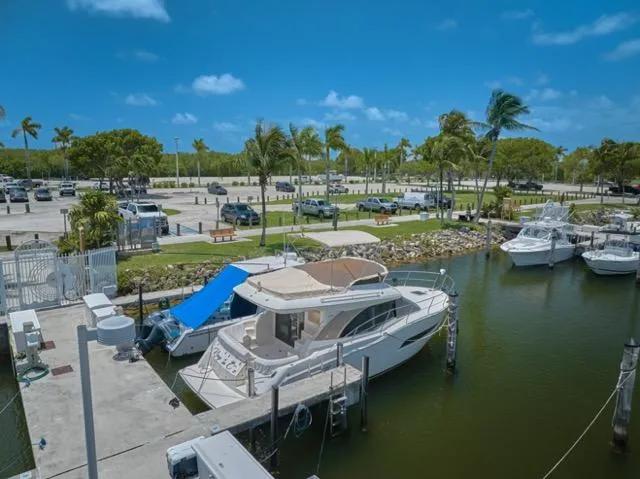 Slide: The Image of 2015 Carver C34 Command Bridge yacht docked in a sunny marina with palm trees. - 33