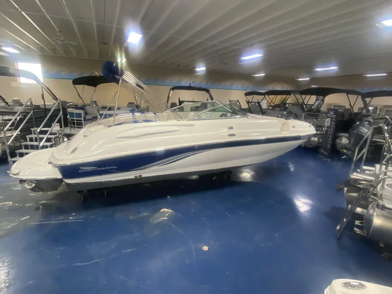 The Image of 2002 Chaparral Sunesta 243 boat displayed indoors, surrounded by other boats. - 0