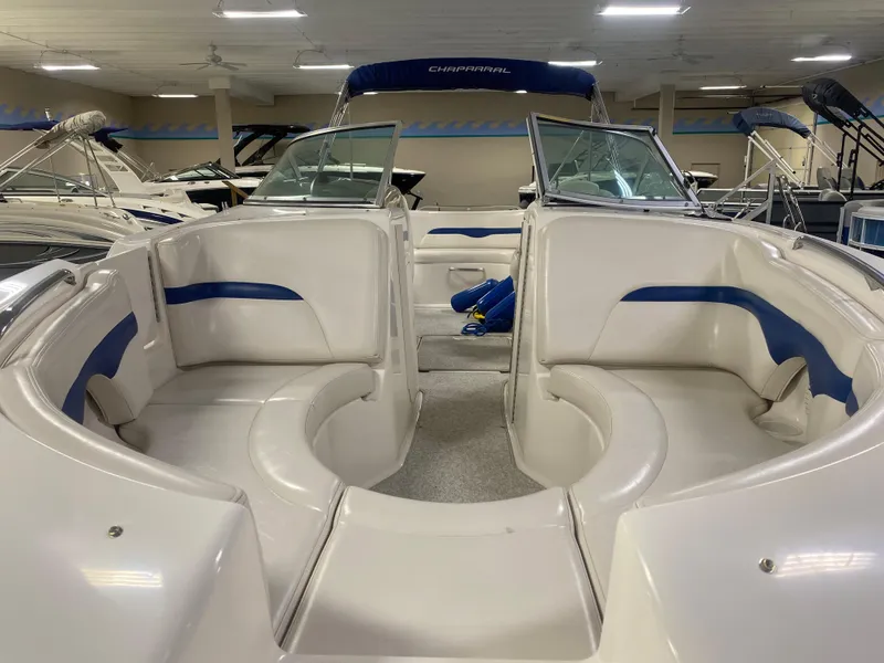 Slide: The Image of 2002 Chaparral Sunesta 243 boat interior with white and blue seating in showroom. - 2