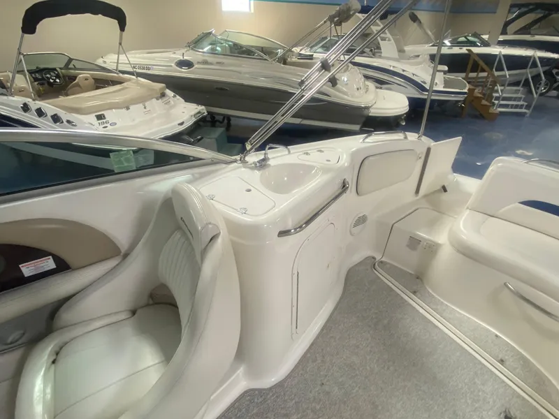 Slide: The Image of 2002 Chaparral Sunesta 243 interior with seating and sink, displayed in a showroom. - 7