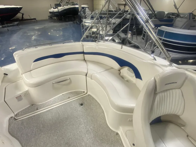 Slide: The Image of 2002 Chaparral Sunesta 243 boat interior with white and blue seating in showroom. - 8