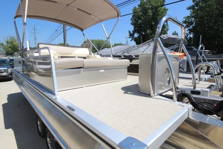 Slide: The Image of 2025 Avalon LSZ Versatile Rear Bench pontoon boat with canopy, parked outdoors. - 5