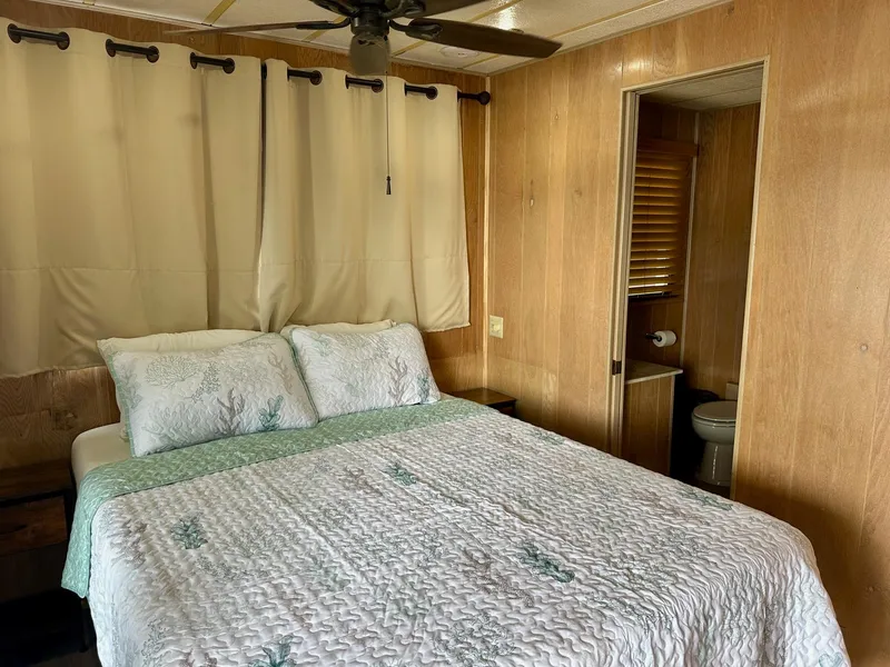 Slide: The Image of Cozy bedroom in 1992 Sumerset 14x66 houseboat with wood paneling and ensuite bathroom. - 10