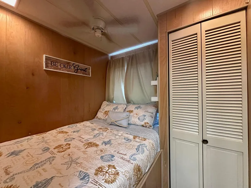 Slide: The Image of Cozy bedroom in 1992 Sumerset 14x66 houseboat with nautical-themed bedding and wooden decor. - 7