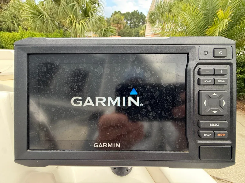 Slide: The Image of Garmin navigation system on 2022 Boston Whaler 160 Super Sport boat, surrounded by greenery. - 11