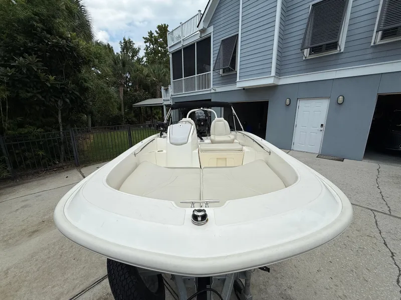 Slide: The Image of 2022 Boston Whaler 160 Super Sport boat parked near a modern house. - 4