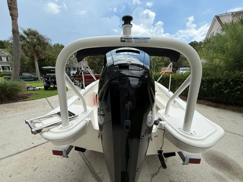 Slide: The Image of 2022 Boston Whaler 160 Super Sport boat, rear view with outboard motor, parked outdoors. - 5