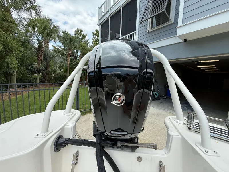 Slide: The Image of 2022 Boston Whaler 160 Super Sport boat engine, parked near a house with palm trees. - 8